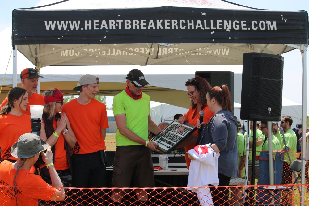 People accepting a plaque that reads "Heart Breaker"